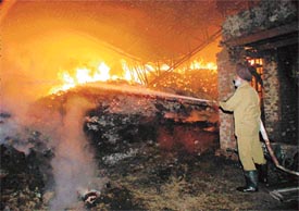 A Fire Brigade man tries to put out the flames at a dyeing unit at Bhamian Kalan village