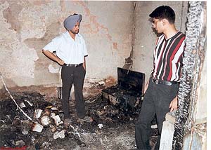 Two students stand amid the gutted room at the ill-maintained hostel of the Government Medical College in Patiala