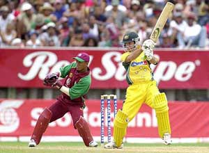 Ricky Ponting of Australia hits a boundary as West Indies wicket keeper Carlton Baugh looks on