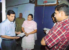 Mr Anurag Verma, Deputy Commissioner, Ludhiana, examines the attendance register of the DEO office during a suprise visit