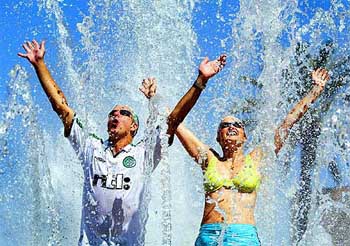 Celtic fans cool down in a fountain in Seville
