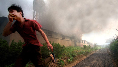A Chinese man flees a burning factory on the outskirts of Hangzhou