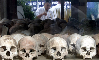A villager prays at a memorial Stupa, filled with more than 8,000 skulls of the victims of Khmer Rouge at the "killing fields" site, located on the outskirts of Phnom Penh