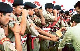 Newly inducted constables queue up for a glass of water after their passing-out parade