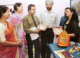 A representative of Pidilite Industries shows craft creations to faculty members of NIFD