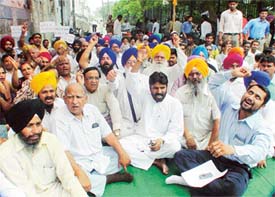 BJP, SAD and BSP workers stage a dharna in front of the municipal corporation office here on Wednesday