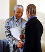 Former South African President Nelson Mandela shakes hands with England soccer captain David Beckham