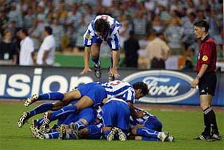 Referee Lubos Michel watches as FC Porto's Nuno Valente jumps onto his team-mates to celebrate Derlei Silva's winning goal 