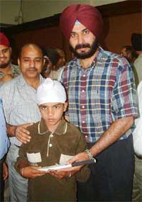 Former Test cricketer and now commentator, Navjot Singh Sidhu presents an autographed cricket bat