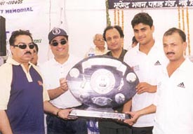 Delhi Transport Minister Ajay Maken, along with Sunil Khanna of DDCA, presenting the Goswami Ganesh Dutt Cricket Trophy to ONGC skipper Gagan Khoda 