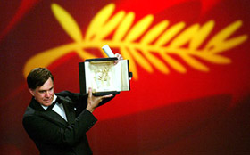 US director Gus Van Sant holds the Palme d'Or award for his film "Elephant"