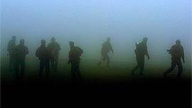 Turkish soldiers walk through dense