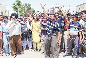Shopkeepers of khoka market, Phase I, protest outside the PUDA office against the removal of encroachments in SAS Nagar on Thursday. 