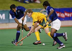 Australia's Dean Butler weaves his way through India's Gagan Ajit Singh and captain Dhanraj Pillay 