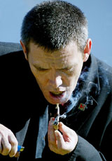 Justin Brash, who suffers from AIDS, lights up his pipe containing cannabis during one of his daily intakes