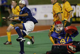 India�s Prabhjot Singh (left) leaps over Australian goalkeeper Mark Hickman during their match of the three-nation men�s hockey tournament