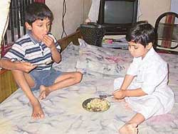Neeraj (6) and Ankita (4), unmindful of the tragedy, have lunch at a