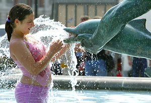 A young girl cools off in a fountain at Trafalgar Sqaure