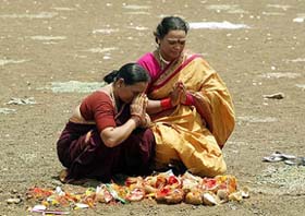 In the hope of early rains, Hindu women make an offering of coconuts