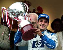Juan Carlos Montoya of Colombia holds up the trophy