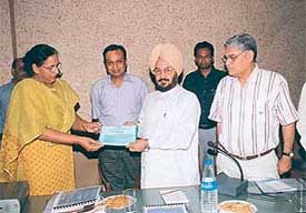 Mrs H.K. Bahia, Managing Director, Housefed, presents a dividend cheque for Rs 72 lakh to Mr Lal Singh, Finance and Cooperation Minister, Punjab
