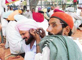 A patwari gets his ear cleaned during a protest by the Revenue Patwar Union