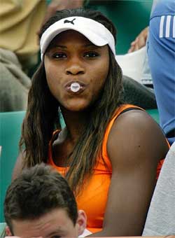 Serena Williams of the US blows a bubblegum while watching her sister's match against Vera Zvonareva of Russia 