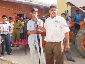Harinder Kumar shows the shotgun allegedly used by his neighbours in an attack on his brother