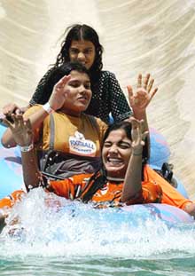 Young women enjoy and keep themselves cool at an amusement park water slide 