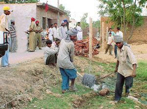Labourers fence the land after demolishing a religious structure at Tira village on Tuesday.