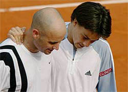 Andre Agassi of the US congratulates Guillermo Coria of Argentina