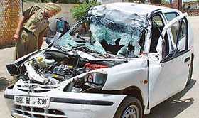 A policeman inspects the car which rammed into a stationary truck on the Chandigarh-Ambala highway at Bhankharpur village, about 3 km from Dera Bassi, late on Wednesday night.