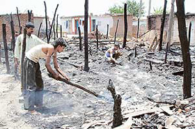 Residents of Shaheed Udham Singh Colony, SAS Nagar, try to salvage household items after a fire gutted their jhuggis on Thursday.