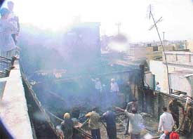 Smoke bellows out of a furniture shop which was destroyed in a fire in Lakkar Bazar