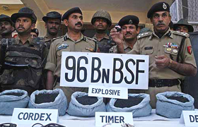 A senior BSF officer displays explosives and other material recovered form a Hizbul Mujahiddin hideout