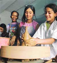 Students work with clay on a potter�s wheel at a workshop 