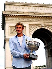Spain's Juan Carlos Ferrero poses in front the Arc de Triomphe with the French Open trophy