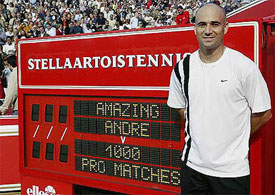 US tennis star Andre Agassi stands next to a scoreboard acknowledging the completion of his 1000th professional tennis match