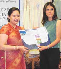 Model Mandeep Walia hands over an air ticket to Australia to a relative of a "lucky couple"