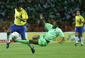 Brazil's Kleberson fights for the ball as Nigeria's Udeze Ifeanyi makes a flying tackle
