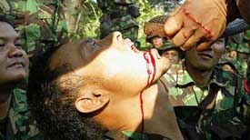An Indonesian journalist drinks snake blood during a jungle survival lesson at the Sanggabuana mountain