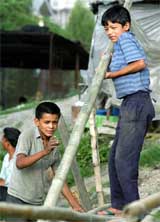 Tara Bhujel, 13, and Raj Kumar Karki, 12, pile bamboo poles 