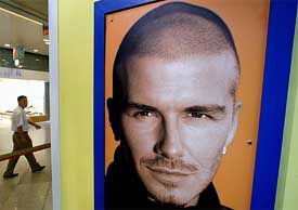 A poster of English soccer star Beckham hangs at a sports store in Beijing 