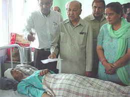 Chief Minister Vir Bhadra Singh presents money to one of the injured