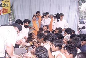 Activists of the All India Punjabi Vikas Morcha distributing prasad at the asthi kalash ceremony.
