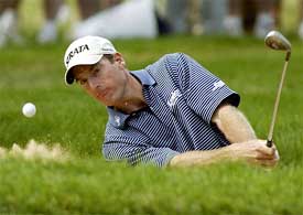 Jim Furyk hits from a sand trap on the sixth hole