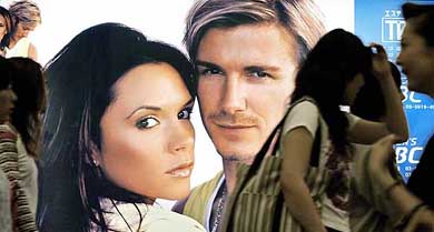 Japanese women walk past a poster at a beauty-treatment clinic, featuring English soccer star David Beckham and his wife Victoria