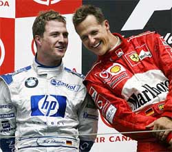 Ferrari driver Michael Schumacher of Germany shares a laugh with brother Ralf Schumacher