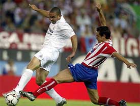 Real Madrid's Brazilian striker Ronaldo is tackled by Atletico Madrid's Jose Antonio Garcia Calvo