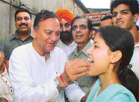 Filmstar Sunil Dutt offers sweets to Tulsa, who got the second place in the plus two examination of the Punjab School Education Board